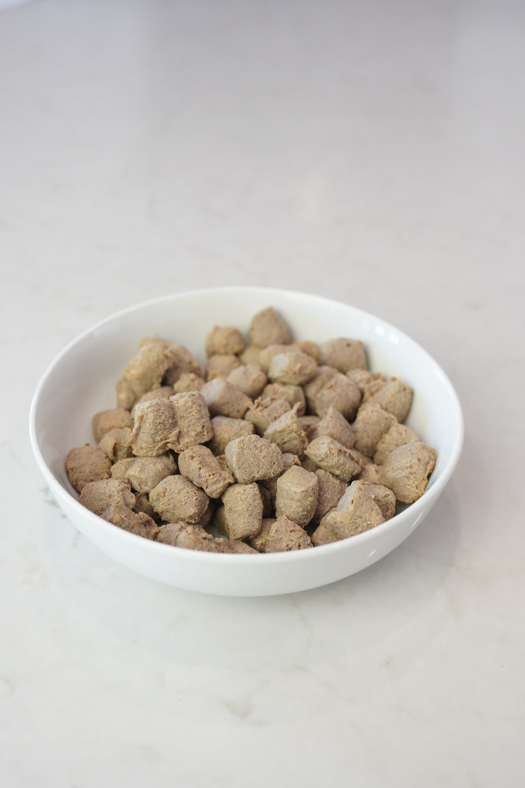 white bowl filled with frozen dog food nuggets